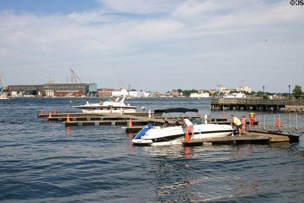 Boats on Piscataqua River with Portsmouth Naval Shipyard (established 1800) on far bank. Portsmouth, NH.