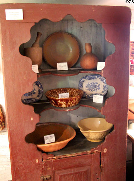 Wall cupboard (c1710) with earthenware plates & bowls (early 1800s or prior) at Woodman Museum. Dover, NH.