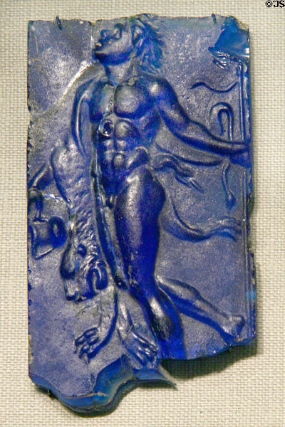 Roman cast glass plaque with satyr carrying body of lion (1stC) at Corning Museum of Glass. Corning, NY.