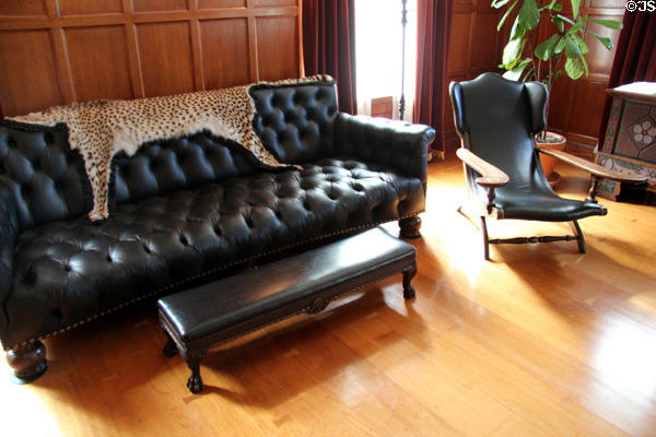 Sofa with leopard skin throw & wide arm reclining chair in billiard room at Eastman House. Rochester, NY.