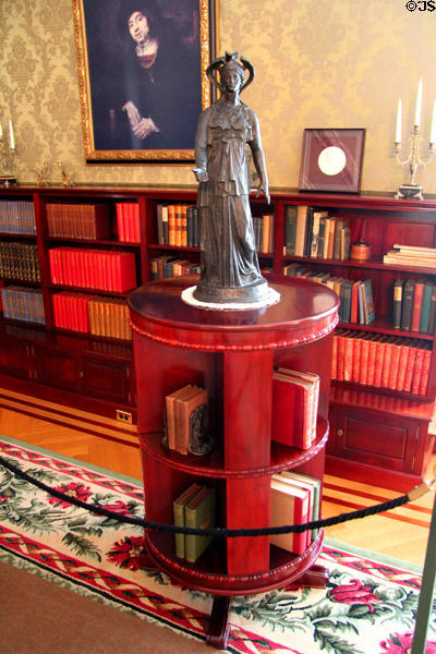 Circular book stand & statue of classical goddess in East Room at Eastman House. Rochester, NY.