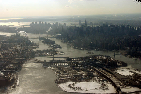 Manhattan skyline beside East River with arched rail Hell's Gate, Triborough Suspension & Queensboro Bridges from air. New York, NY.