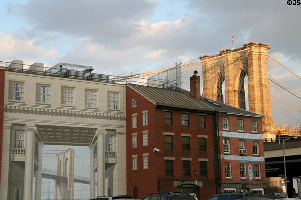 Real Brooklyn Bridge over mural Brooklyn Bridge in South Street Seaport Historic District. New York, NY.