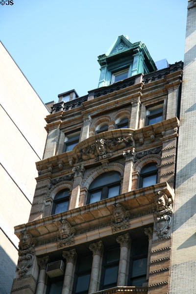 Narrow heritage townhouse with ledges supported by stone heads (744 Broadway at Astor Place). New York, NY.