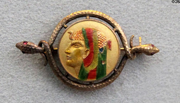 Egyptian revival gold & enamel brooch with pharaoh profile held by snakes (c1880) from Newark, NY at Metropolitan Museum of Art. New York, NY.