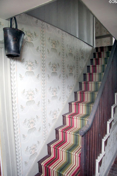 Narrow staircase & fire bucket in front hall at Custom House Museum. Sag Harbor, NY.