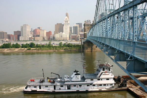 Cincinnati skyline with Roebling Bridge & river barge. Cincinnati, OH.