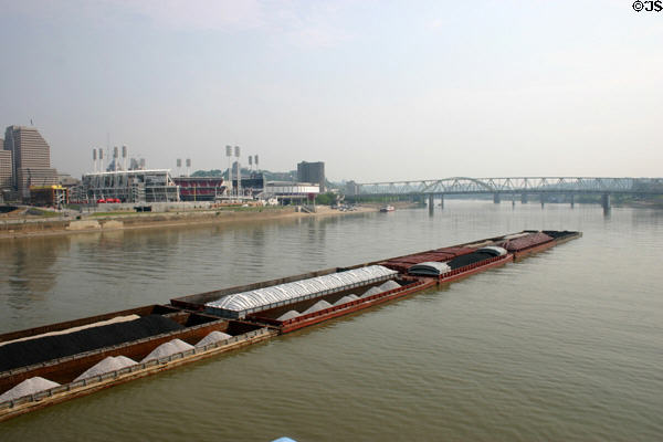 Barge on Ohio River sails past Great American Ball Park & series of bridges. Cincinnati, OH.
