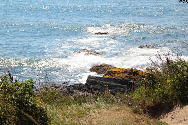 Waves break on rocks seen from The Breakers. Newport, RI.