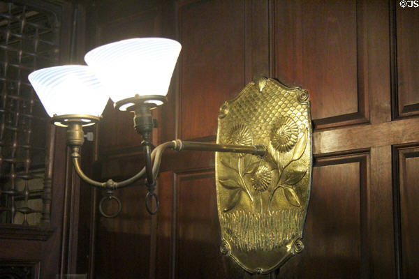 Gaslamp sconces with hammered brass wall brackets with dahlia flower design by Stanford White in Dining Room at Kingscote. Newport, RI.