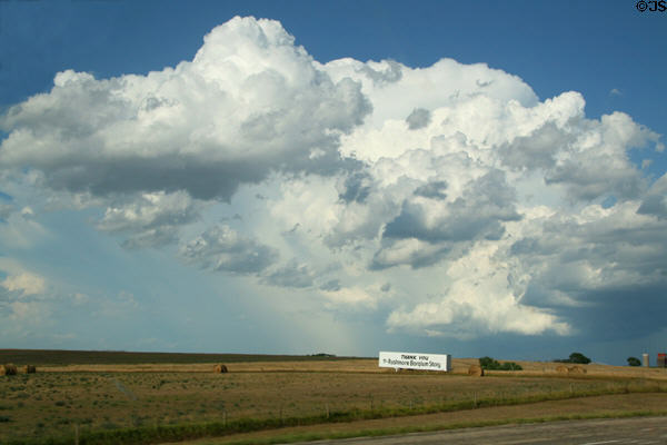 Clouds over hay bails & South Dakota sign. SD.