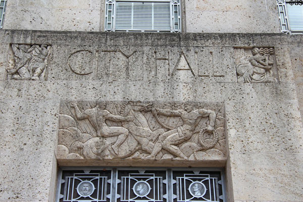 Limestone relief of two men taming horses like government over entrance door of Houston City Hall. Houston, TX.