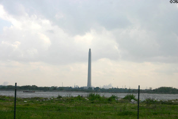 San Jacinto monument beside Texas ship channel with petroleum refinery beyond. Houston, TX.