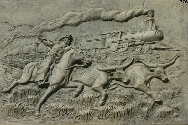 Sculpted history panel of cowboy driving longhorns to railroads by Michael O'Brien on Texas State History Museum. Austin, TX.