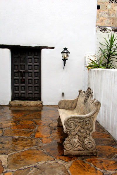 Courtyard carved bench & colonial wooden door of Spanish Governor's Palace. San Antonio, TX.