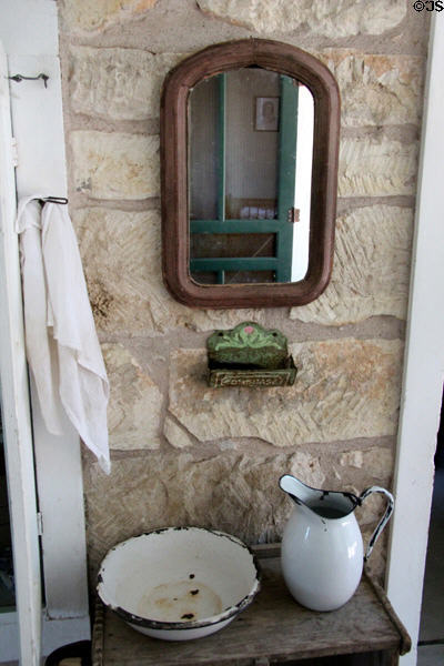 Exterior washbasin, pitcher, comb case & mirror at Sauer-Beckmann Farmstead. Stonewall, TX.