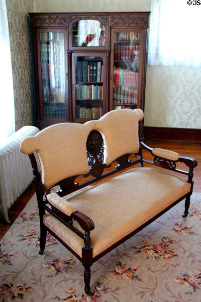 Wood & upholstered settee before glass-front bookcase at Chambers House Museum. Beaumont, TX.
