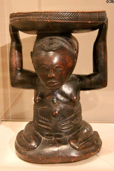 Wood stool supported by kneeling female figure (19th-20thC) by Luba culture of Democratic Republic of the Congo at Dallas Museum of Art. Dallas, TX.