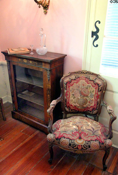 Bookcase & tapestry covered armchair at French Legation Museum. Austin, TX.
