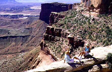 Hikers sitting at overlook at Canyonlands National Park. UT.
