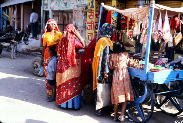 Women buying items from street vendor in Mandawa. Mandawa, India.