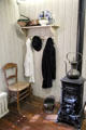 Small stove, wooden chair & coat rack at Van Gogh House in Cuesmes. Mons, Belgium.