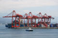 Seabus commuter ferry against cranes of Vancouver container port. Vancouver, BC.