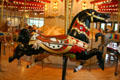 Black hunting horse with rabbit on C.W. Parker Carousel at Burnaby Village Museum. Burnaby, BC.
