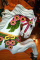 White horse with flowers on C.W. Parker Carousel at Burnaby Village Museum. Burnaby, BC