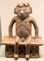 Carchi earthenware seated male figure on bench from Ecuador at Gardiner Museum. Toronto, ON.