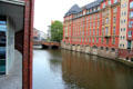 Bridge crossing Alsterfleet waterway lined with buildings. Hamburg, Germany