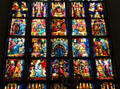 Modern stained glass window features nativity scenes at Frauenkirche. Munich, Germany.