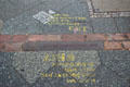 Brick line in pavement marks where Berlin Wall once stood near Checkpoint Charlie. Berlin, Germany.