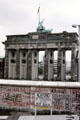 Berlin Wall & Achtung! Sie Verlassen Jetzt West Berlin sign with Brandenberger Gate beyond. Berlin, Germany