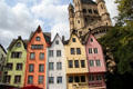 Colorful restored historic dwellings of Fischmarkt area with tower of Great St Martin church in background. Köln, Germany