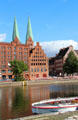 Heritage buildings along Holsten Hafen with St Mary's church beyond. Lübeck, Germany.