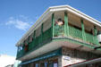 Stone building with green veranda balcony on Bay Street. Roseau, Dominica