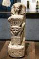 Kneeling figure of architect Senenmut holding symbol of goddess Hathor of granite from Armant at Museum Ägyptischer Kunst. Munich, Germany.