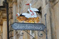 Shop sign painted with stork nest. Bayreuth, Germany.