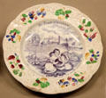 Ceramic promotional plate made in England written in German with image of steam train passing three children eating fruit at Nuremberg Transport Museum. Nuremberg, Germany.