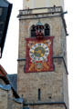 Gothic bell tower of St Martin Lutheran church with more modern clock fixed to exterior. Memmingen, Germany.