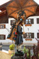 Whimsical street art of peddler carrying load of carvings using a traditional wooden back pack. Oberammergau, Germany.