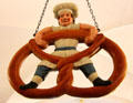 Shop sign of baker boy balancing on a pretzel at Museum of Bread and Art. Ulm, Germany