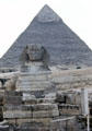 The Sphinx in front of Pyramid of Chephren with original casing at the top. Giza, Egypt