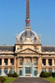 Central clock tower of Ecole Militaire with Eiffel Tower beyond. Paris, France.