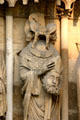 Statue of St Denis holding his severed head on Cathedral. Reims, France.