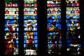 South transept stained glass windows of St. Stephen's Cathedral with figures in Medieval dress. Sens, France.