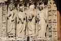 Saints carvings on left portal of Notre Dame Cathedral including St Denis holding head. Paris, France.