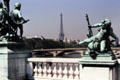 Eiffel Tower seen between sculptural elements of Pont Alexandre III. Paris, France.
