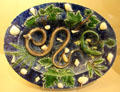 Glazed earthenware platter with moulded snake, lizard, shells & leaves from France at Sèvres National Ceramic Museum. Paris, France.